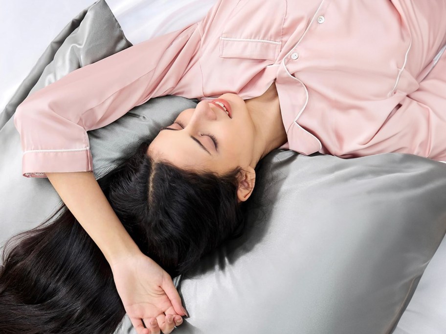 woman in pink pjs laying on gray pillow