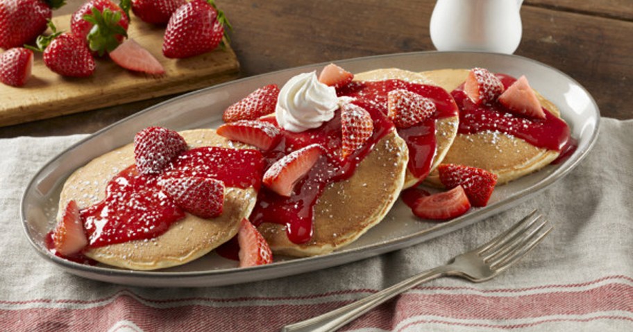 three pancakes with strawberries on top 