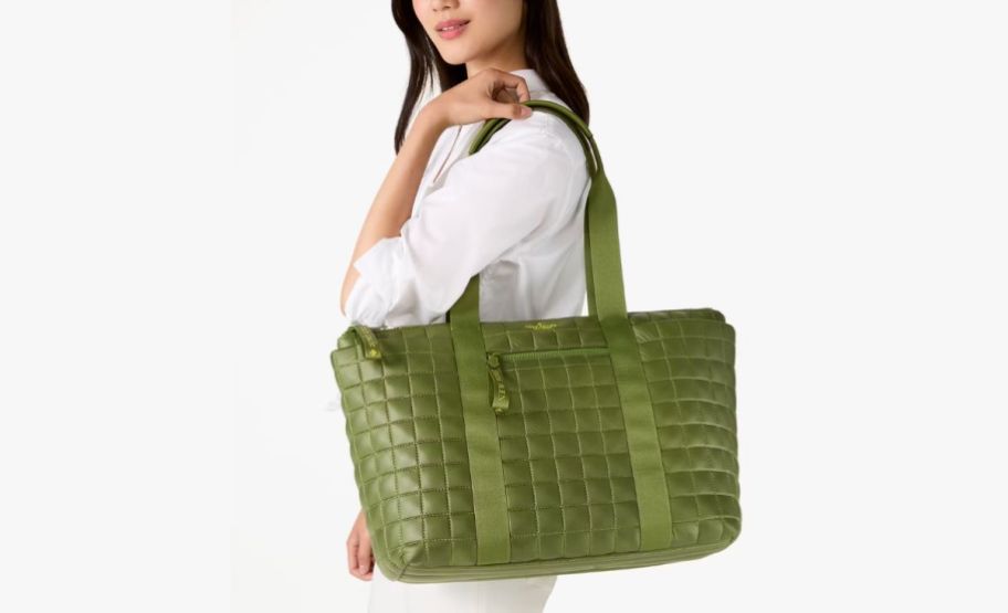 Woman holding oversized green quilted tote bag