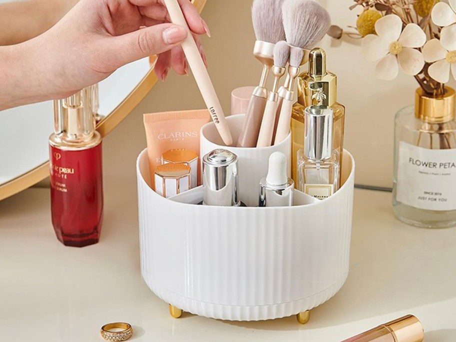 white makeup organizer with brushes on table