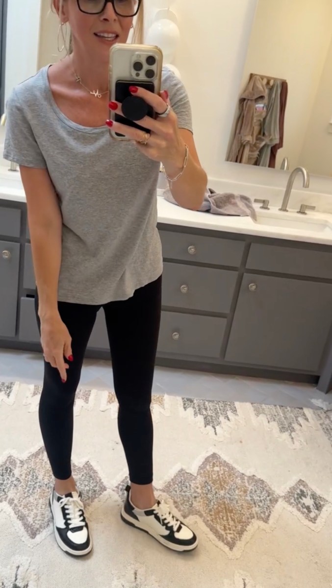 Woman posing in front of mirror wearing gray and black casual outfit 