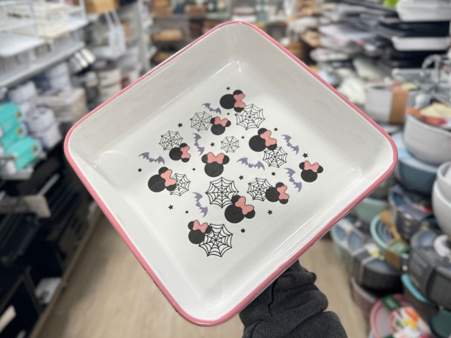 a womans hand holding a minnie mouse halloween serving platter