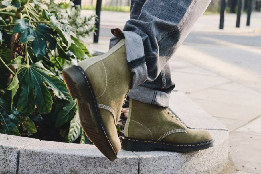 green lace up boots walking on planter