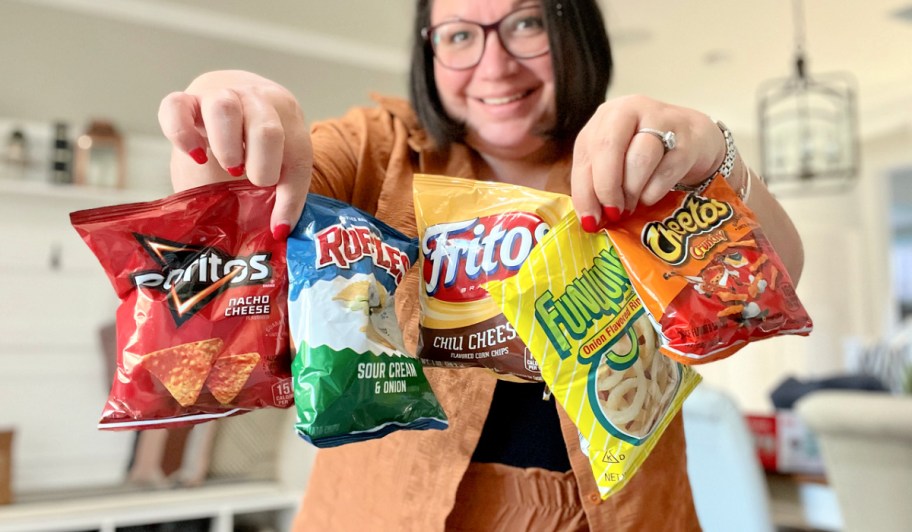 woman holding assorted bags of frito lay chips