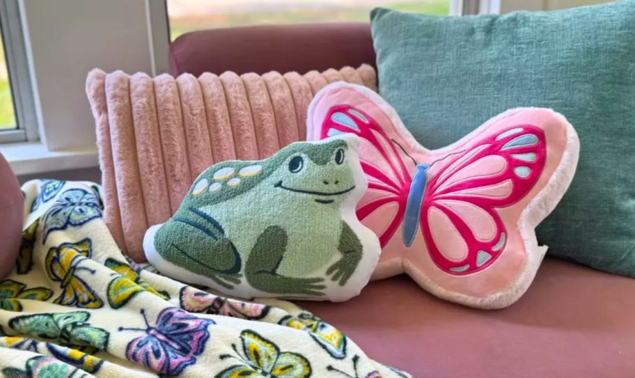 a frog, butterfly, lumbar and square throw pillows on a window seat