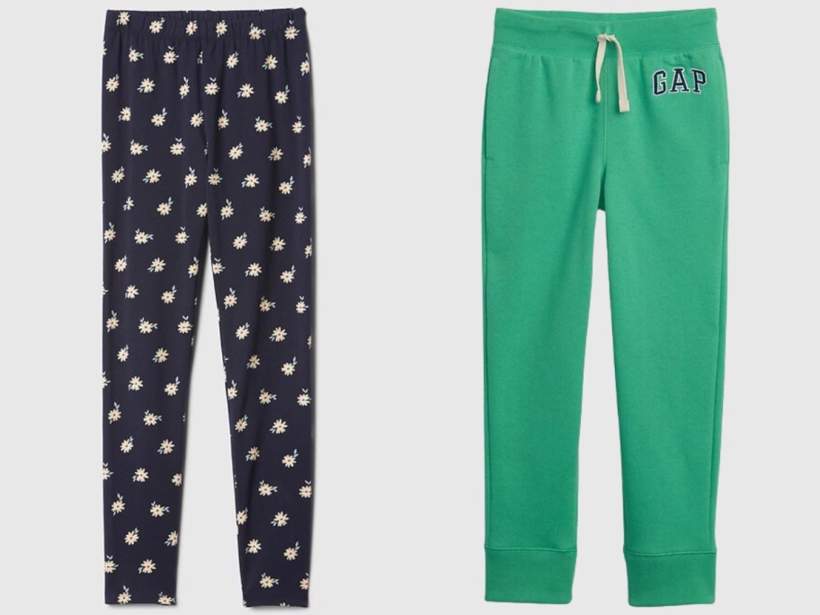 pair of girl's leggings in black with daisies on them next to a pair of boy's green Gap joggers