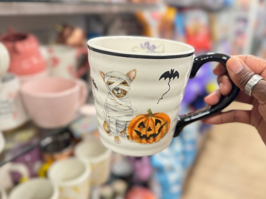 womans hand holding a halloween coffee mug