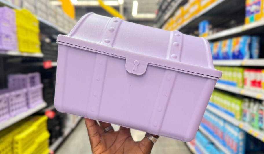 hand holding treasure box in purple inside of a store