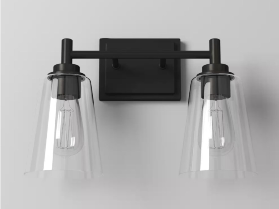 black and glass modern 2 light vanity light with Edison bulbs on a wall