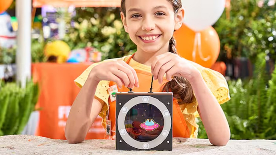 girl holding craft project at home depot workshop