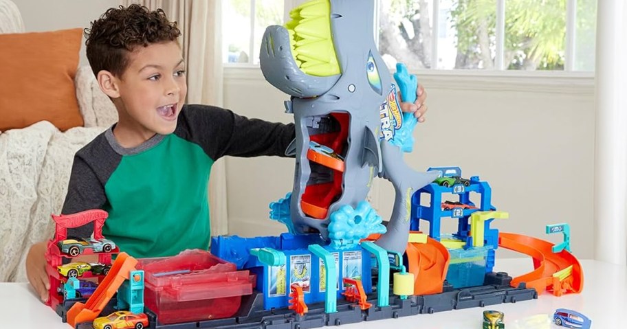 boy playing shark hot wheels set on table