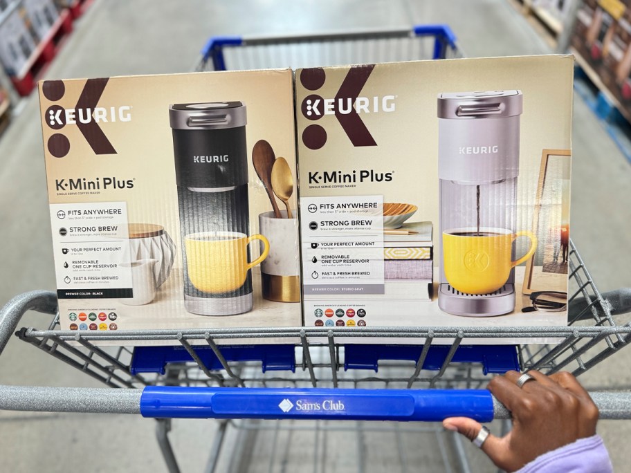 hand pushing cart with purple and gray keurig coffee makers