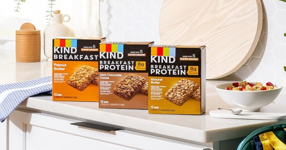 Three boxes of KIND Breakfast Protein bars ona  kitchen counter.