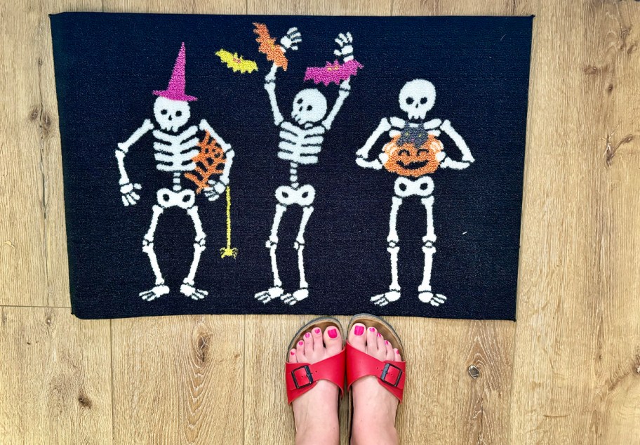 feet standing in front of skeleton doormat