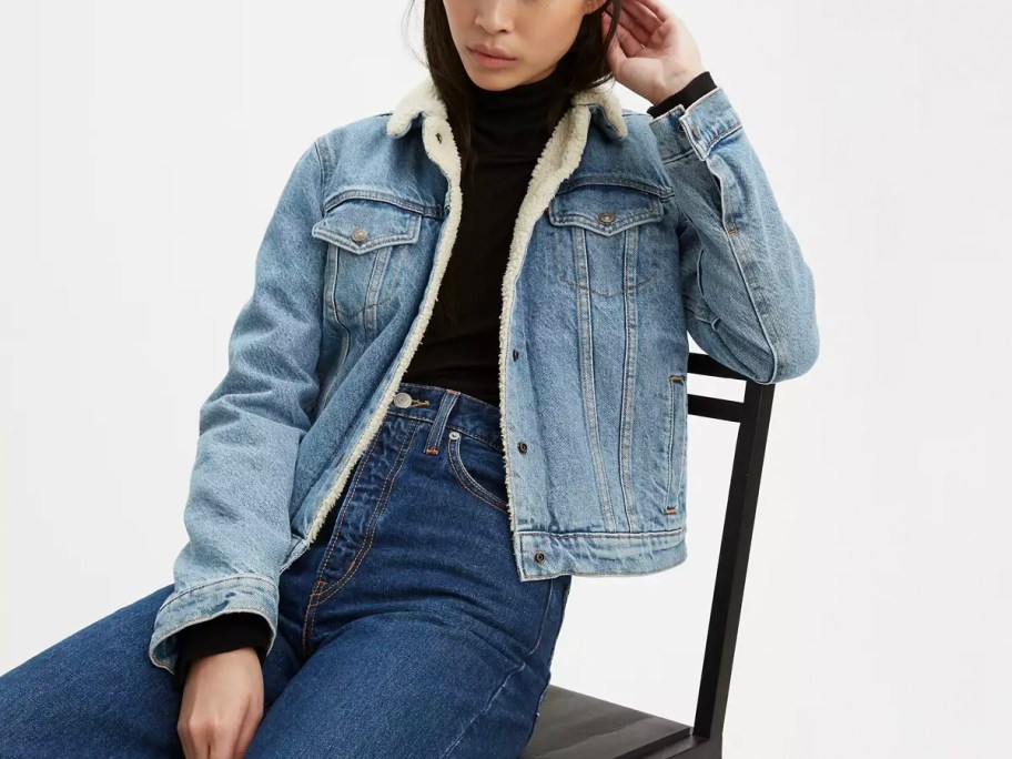 person wearing blue levis jacket sitting on chair