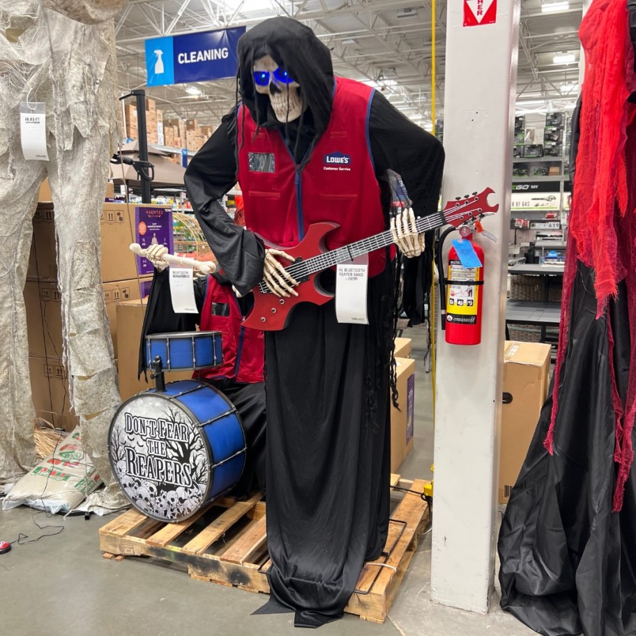 Halloween animatronic of a tall Grim Reaper playing a guitar