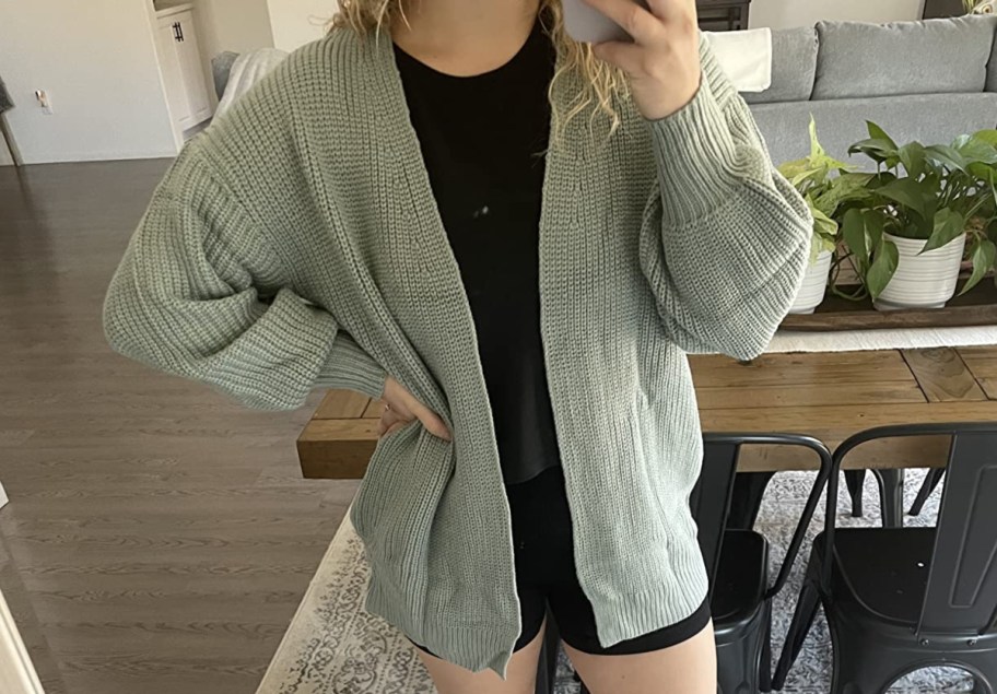 woman taking selfie in green cardigan