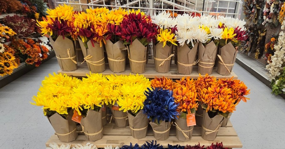 faux mum plants in kraft paper wrapped containers on a display in Michaels