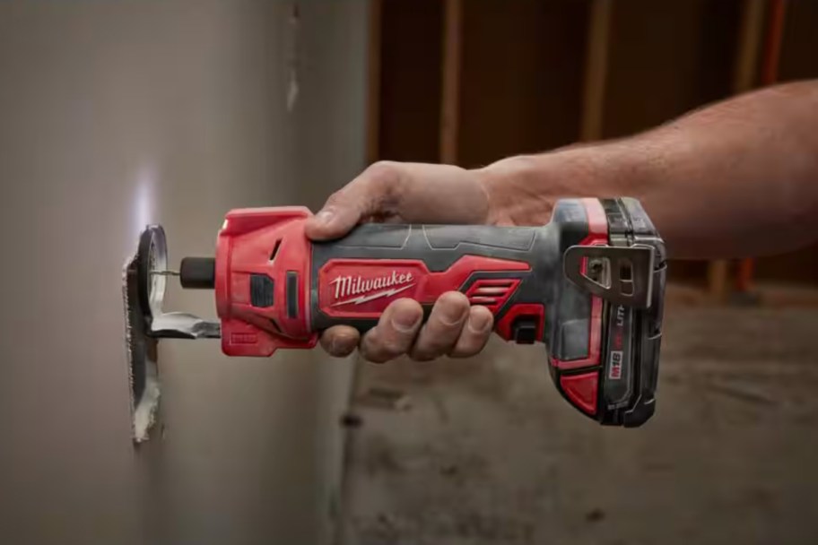 hand using drywall tool on wall 