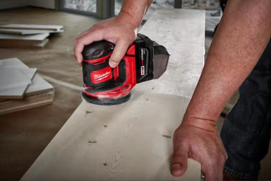 hands using orbital sander