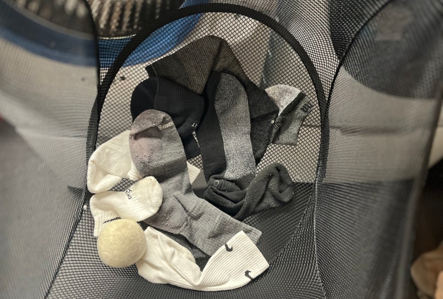 black mesh laundry basket with missing socks in bottom