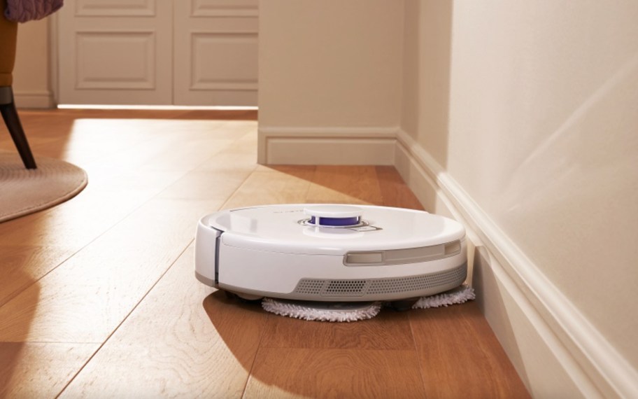white robot vacuum and mop against wall
