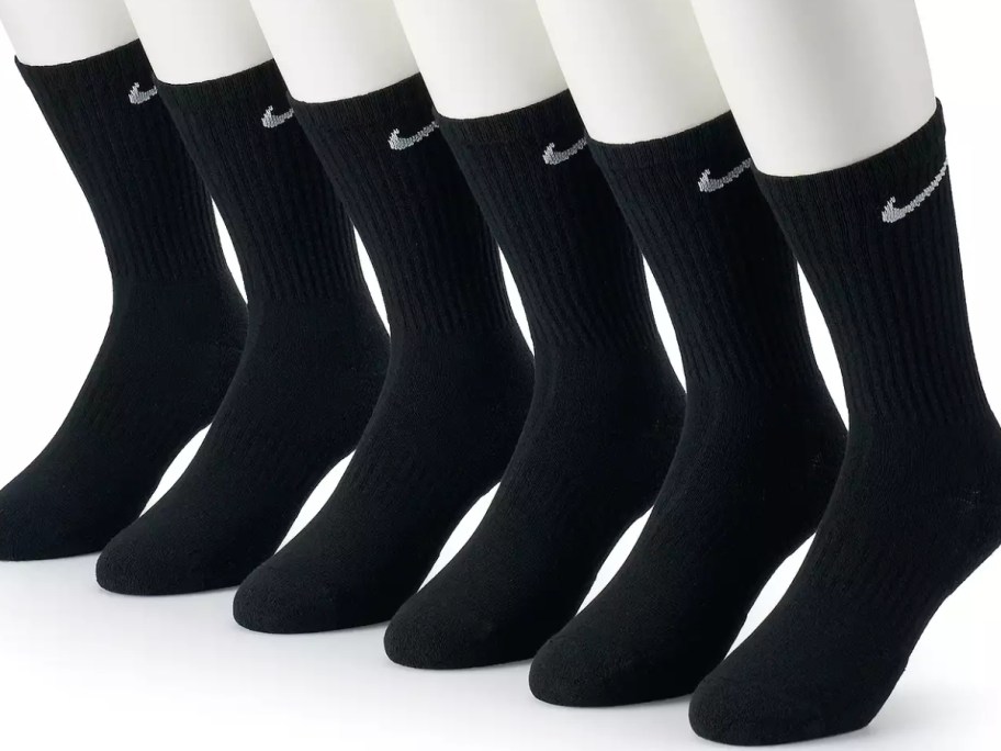 6 mannequin feet wearing black Nike logo crew socks