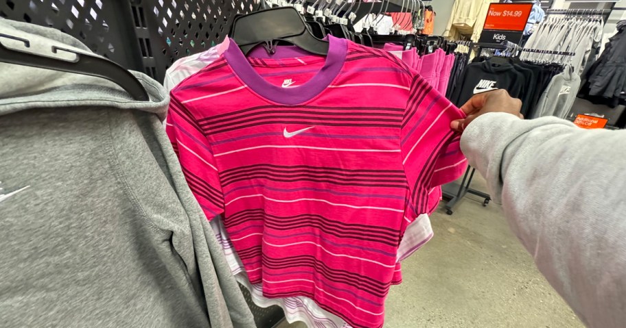 hand reaching for pink striped nike tee