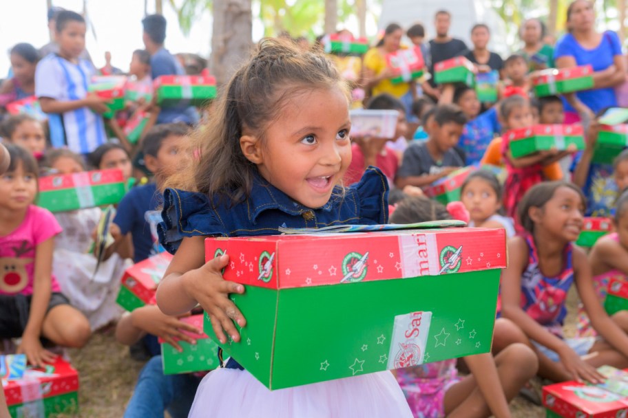 a participant of operation christmas child holding a shoebox 