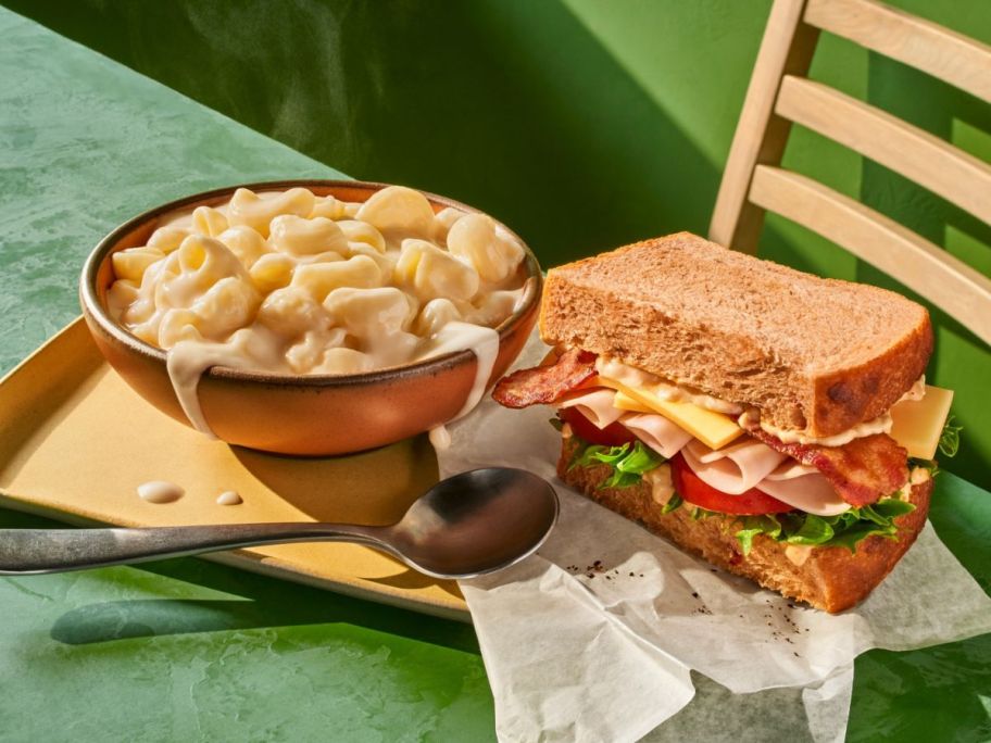 panera mac and cheese and sandwich on table with spoon