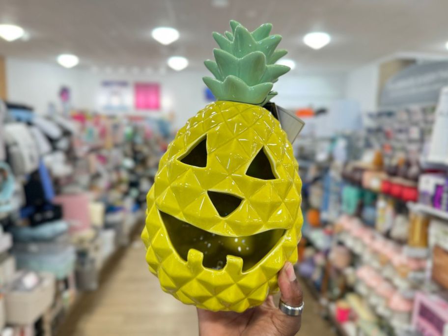 womans hand holding a pineapple jack o lantern