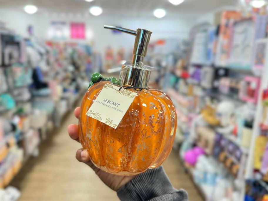 womans hand holding a pumpkin shaped soap dispense