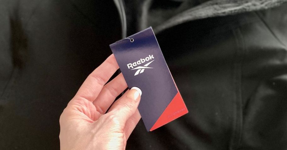 hand holding reebok tag on jacket