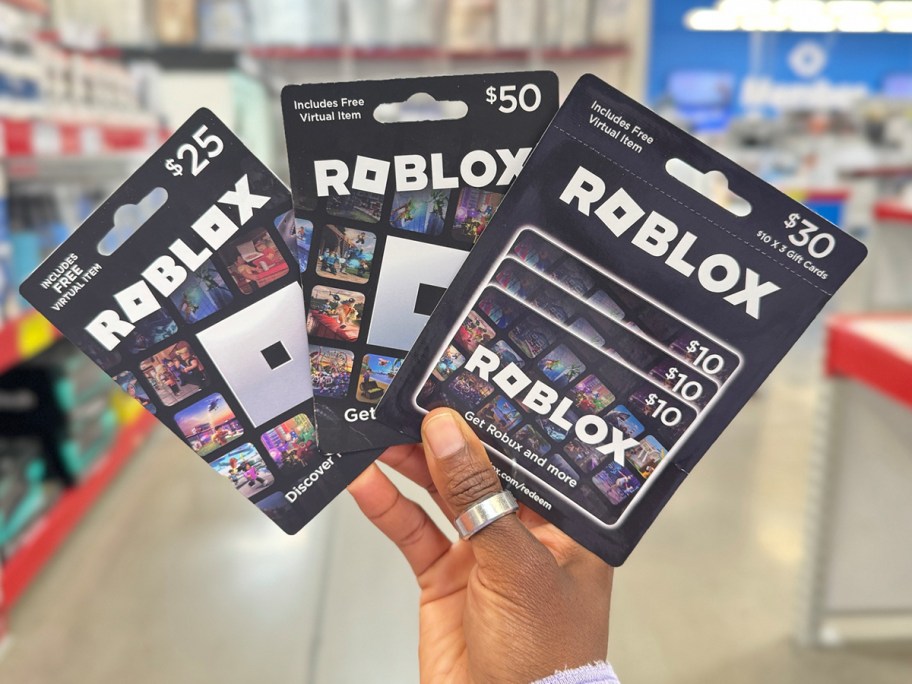 hand holding roblox gift cards