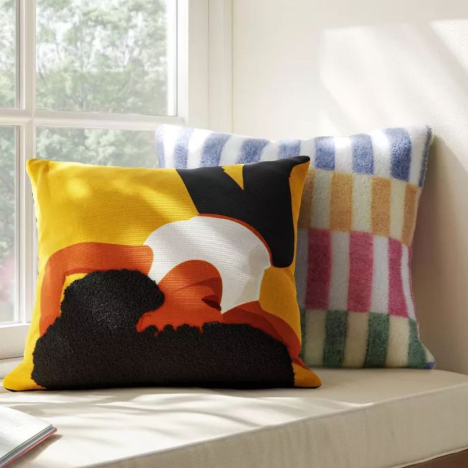 two square throw pillows on a window seat