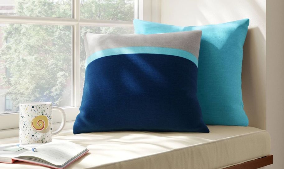 two blue pillows on a window seat