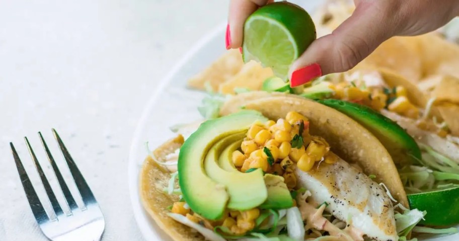 squeezing lime onto a fish taco