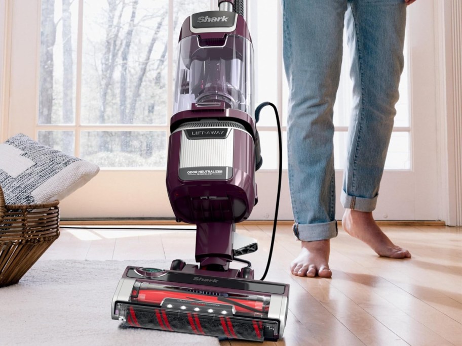 shark vacuum on floor and carpet with person using it
