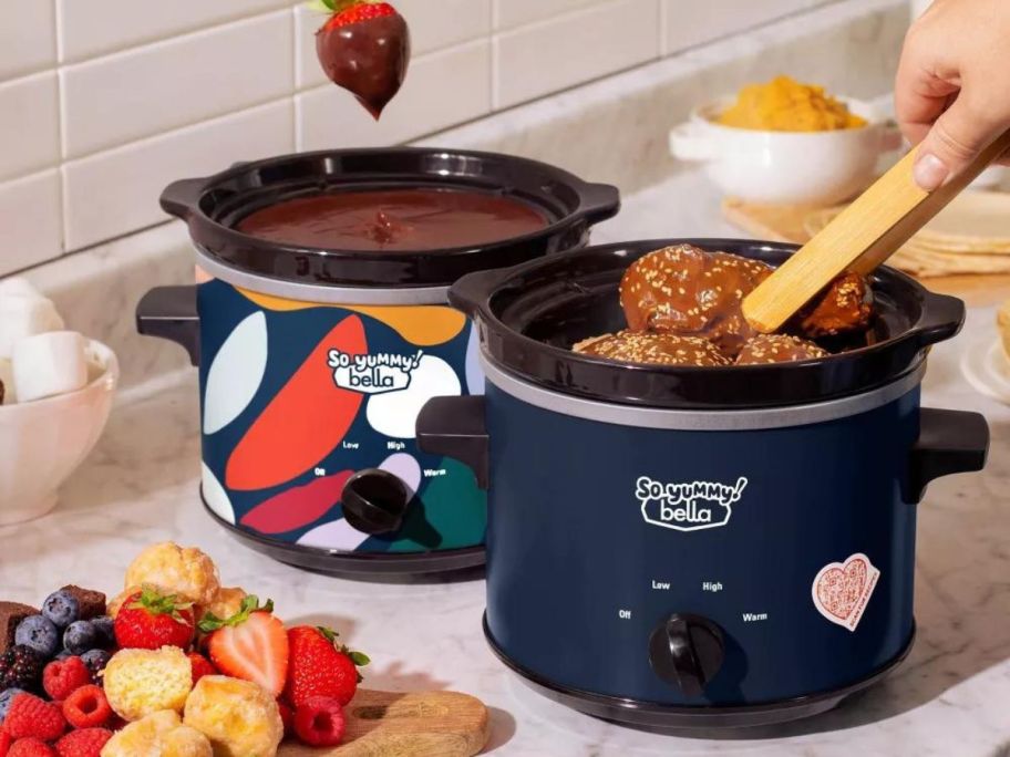 two So Yummy by bella 2-Quart Twin Set Slow Cookers on counter with food cooking inside of them