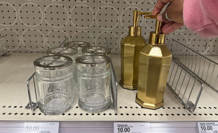 toothbrush holder next to a soap dispenser on a store shelf