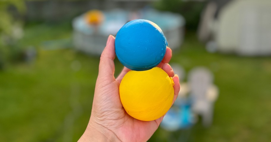 hand holding two water balloons