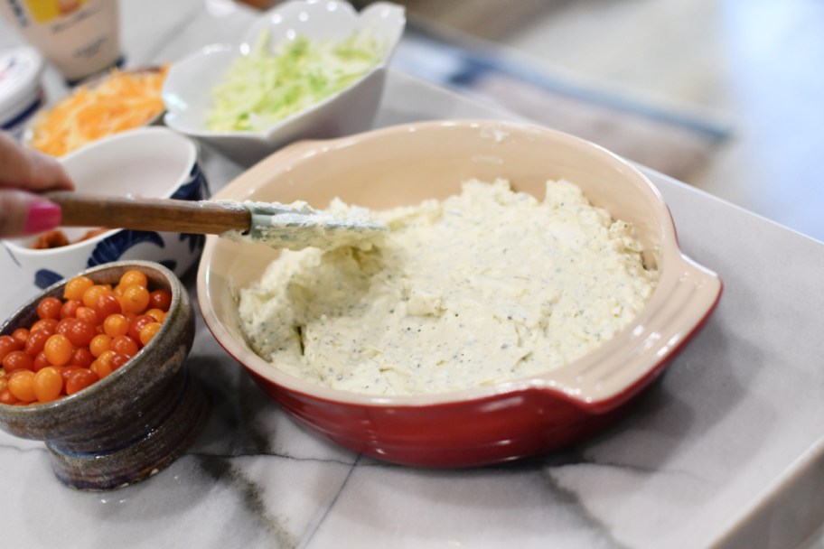 spreading blt dip in a pan 