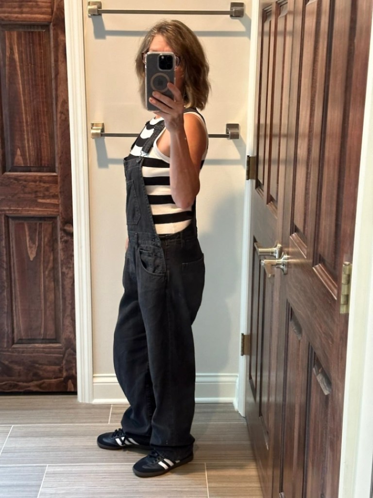 woman wearing overalls with knit striped tank 