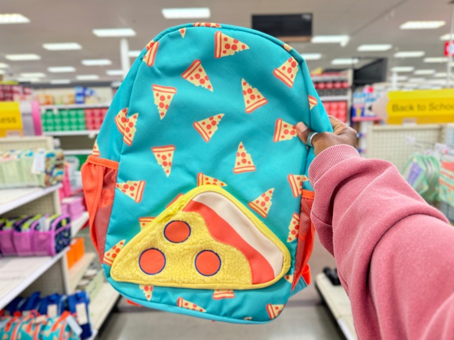 hand holding a kid's blue and yellow backpack with pizza slices on it