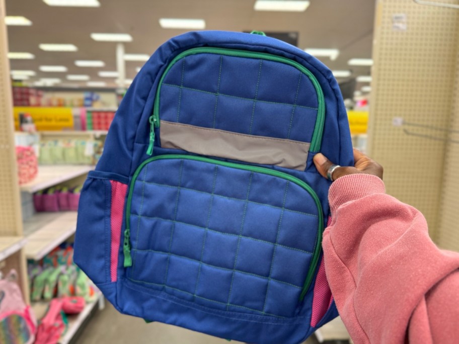 hand holding a blue quilted kid's backpack