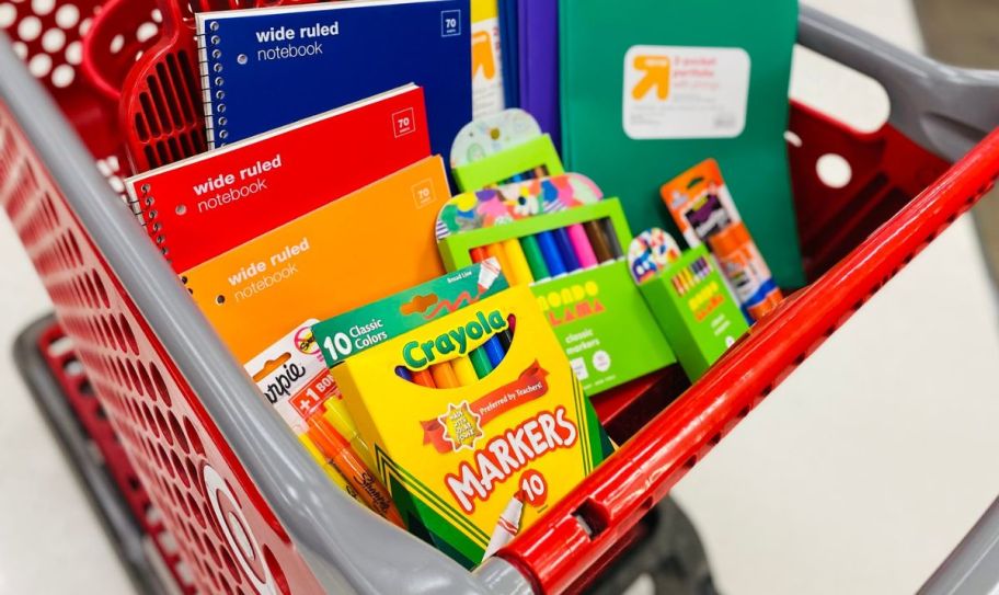 a target shopping cart filled with various school supplies including notebooks, markers, and colored pencils