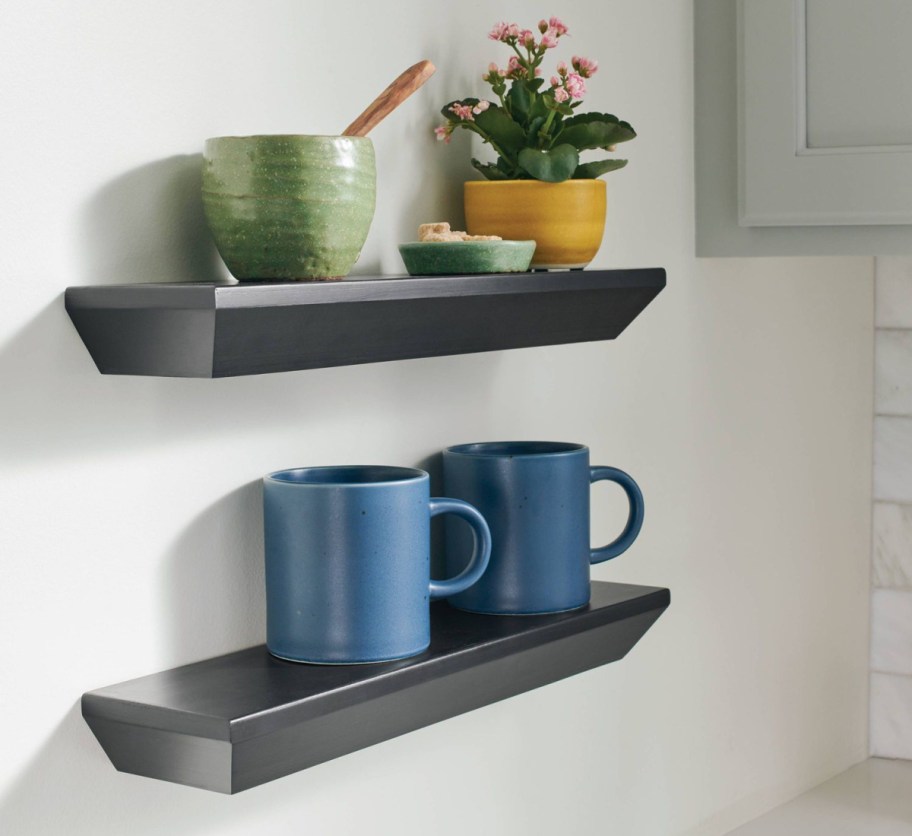 two black shelves with coffee mugs on them