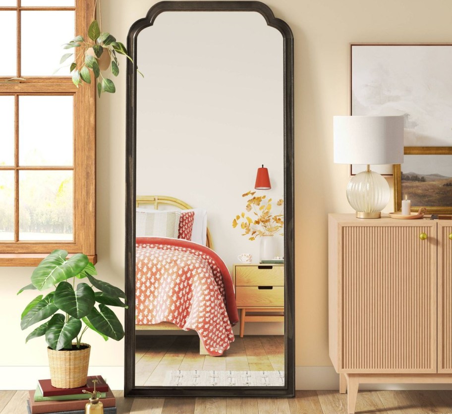 arched black frame mirror against wall