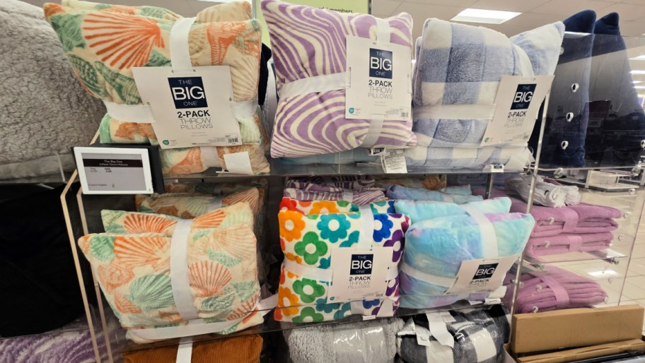 a variety of big one throw pillow two packs on a kohls store shelf display
