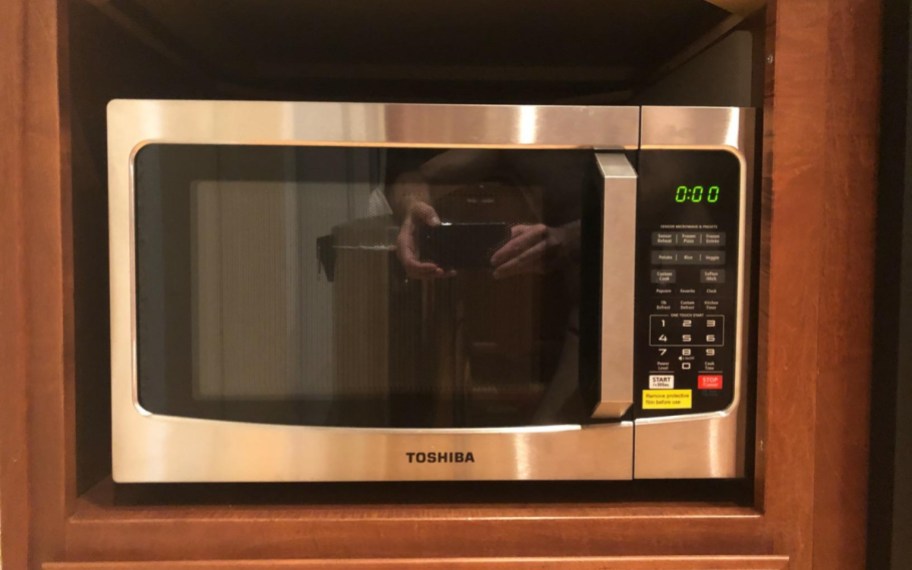 stainless steel microwave in wood cabinet